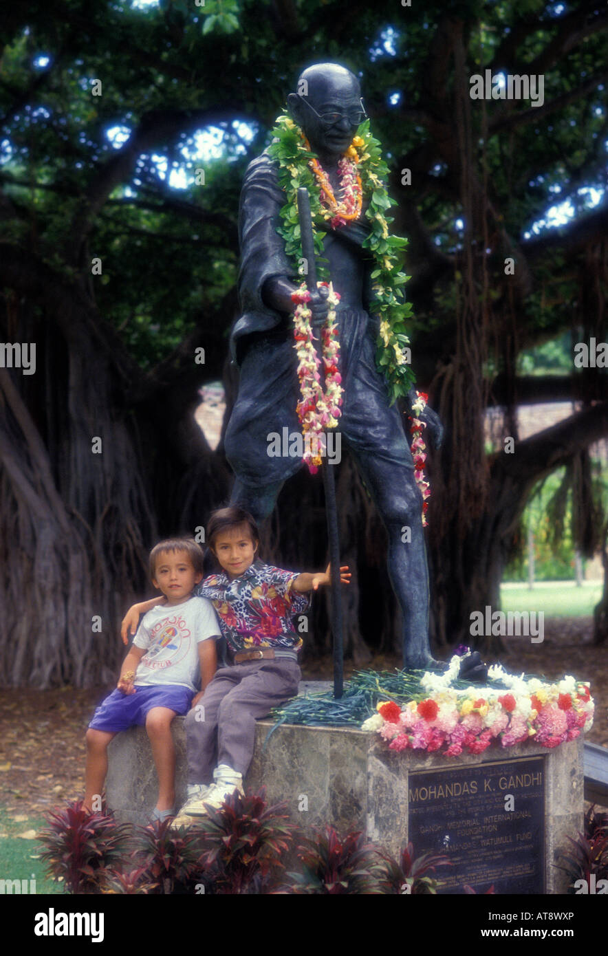 Kids with the Mohandas Gandhi statue in Waikiki, located near the Honolulu zoo. Stock Photo