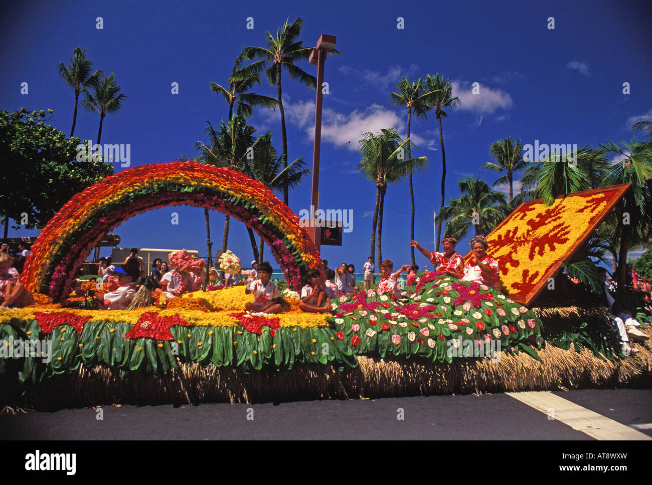 Aunties waving from a colorful float at the aloha week parade in
