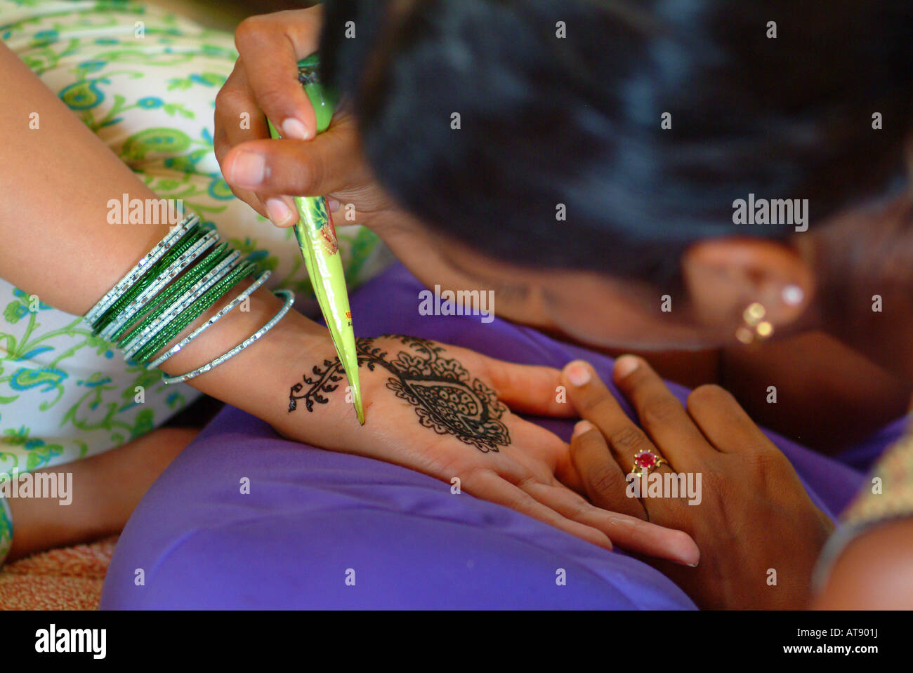 Woman receiving a mendhi ( henna dye ) design  on her hand prior to her indian wedding ceremony Stock Photo