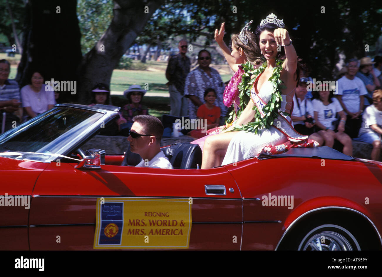 Beauty queens ride a red convertible in the Aloha Week Parade. Stock Photo