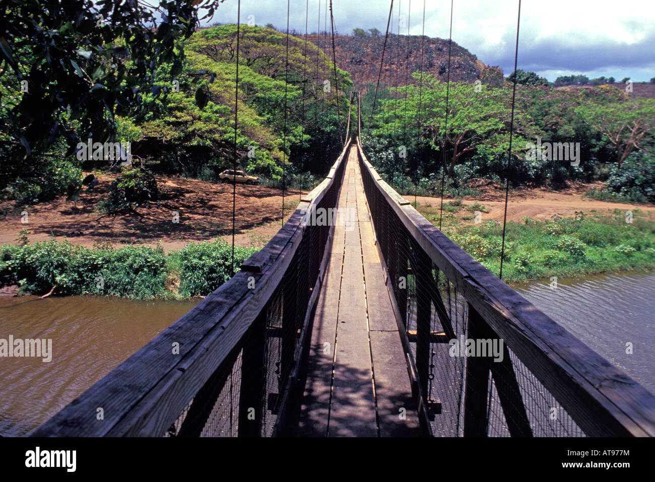 Long view of the old wooden-planked swinging Menehune Bridge over the