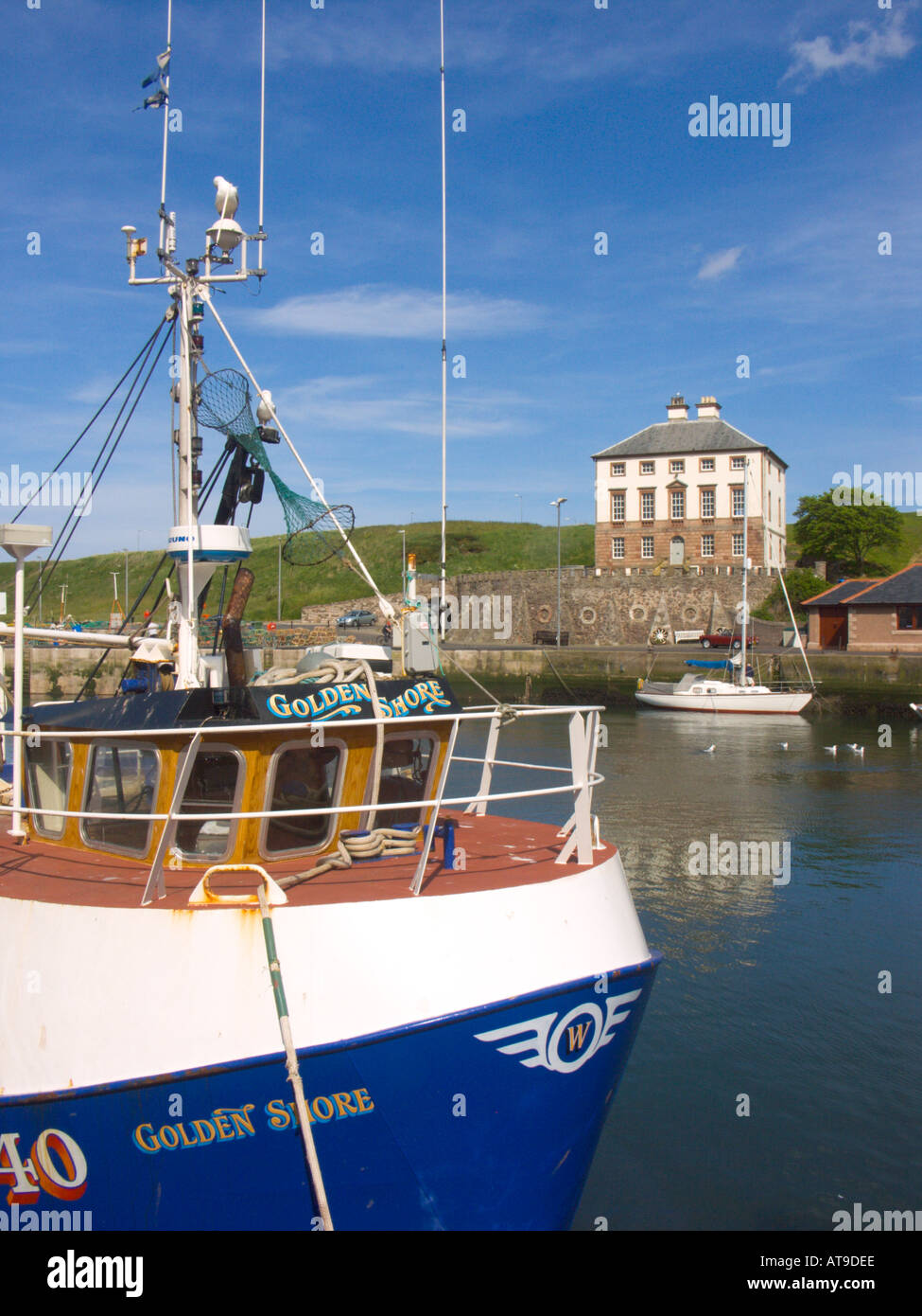 The fishing port of Eyemouth Berwickshire with the 18th century Gunsgreen House and North Sea trawler Stock Photo