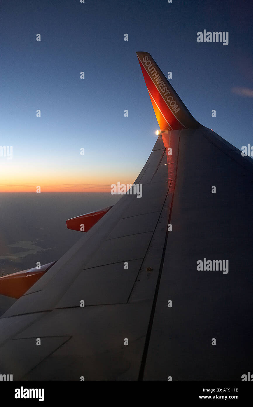 Southwest Airlines Boeing 737 wing with air dam at cruising altitude at sunset Stock Photo