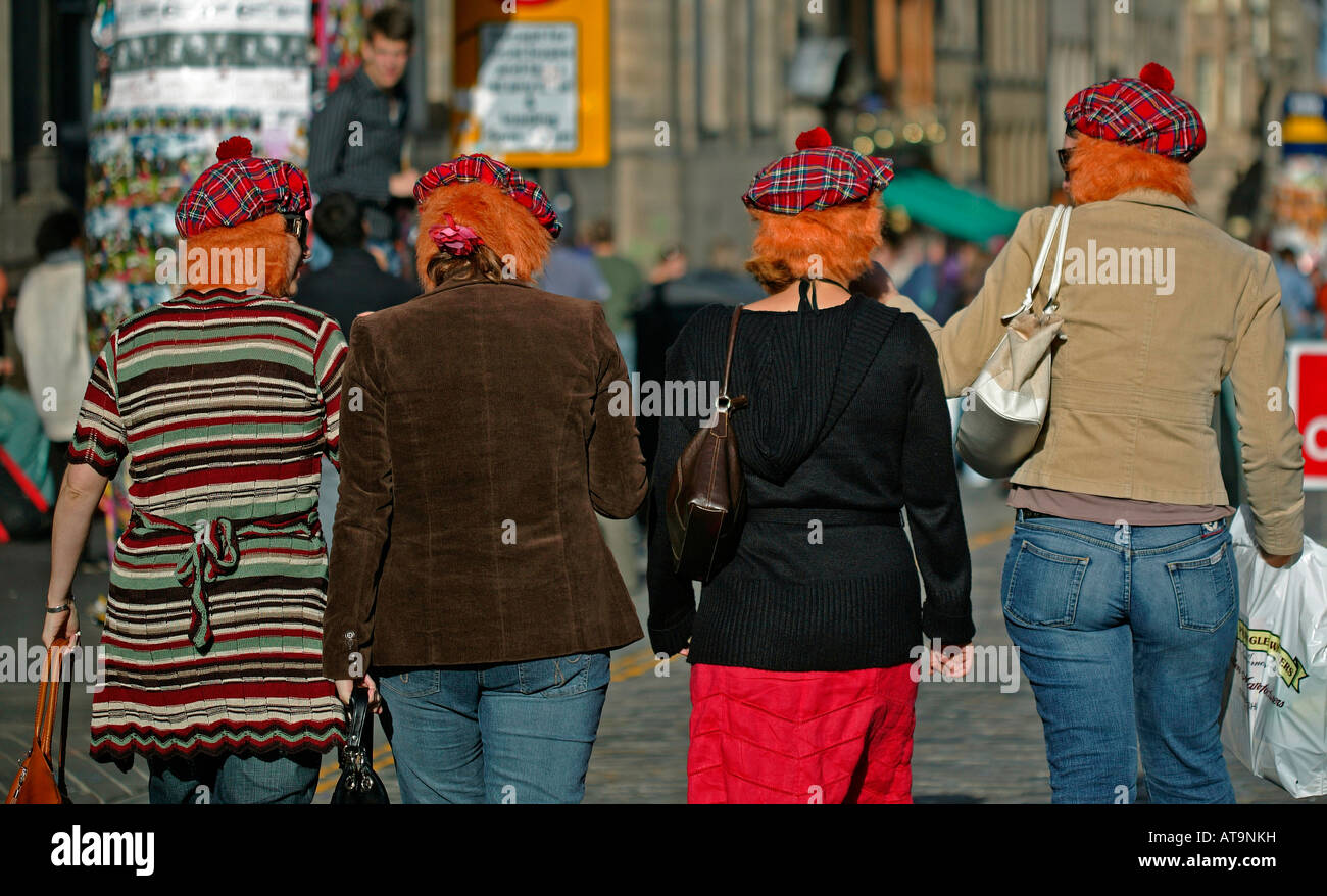 Four females wearing tartan 'Jimmy Hats' walk down High Street during Edinburgh Fringe Festival Stock Photo