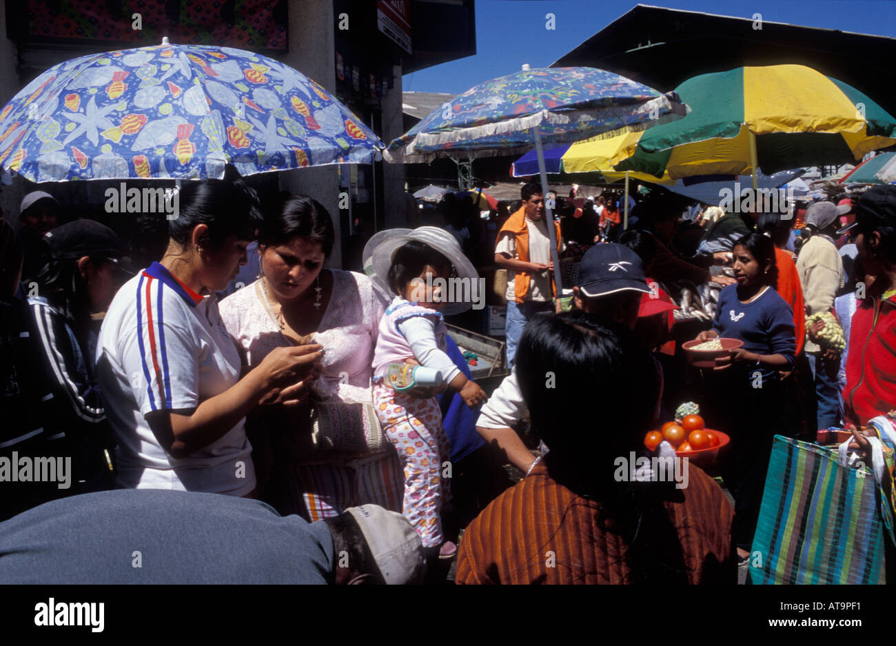 Colourful fruit and vegetable market in Riobamba with a mother holding a baby Stock Photo