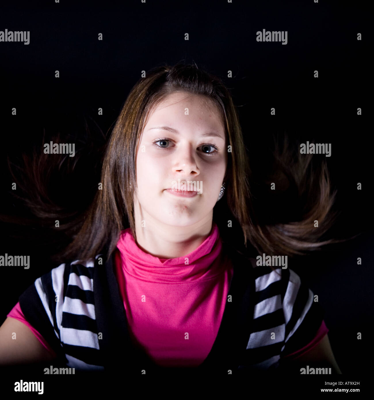 Flat head and shoulders image of young girl with hair aloft Stock Photo
