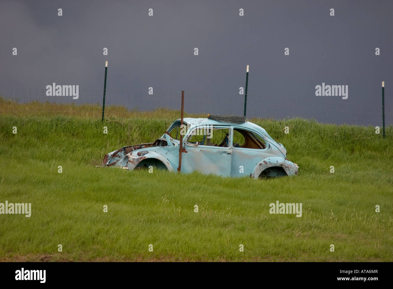 Abandon VW Bug in a field during an approching storm Stock Photo