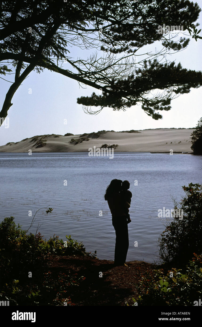 Mother holds daughter at Oregon Dunes National Recreation Area Cleowox Lake in Honeyman State Park Stock Photo