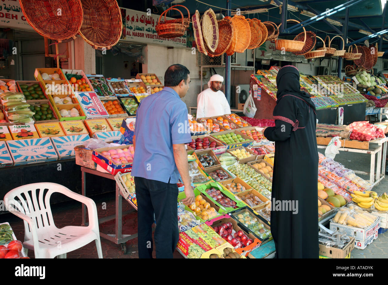 An arab couple buy fruit and veg at the market, Abu Dhabi city, UAE
