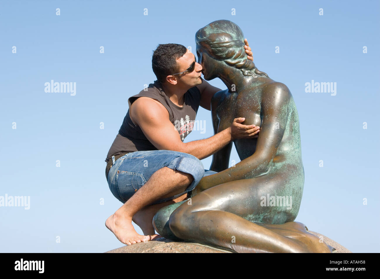 Tourist kissing The Little Mermaid Copenhagen Denmark Stock Photo