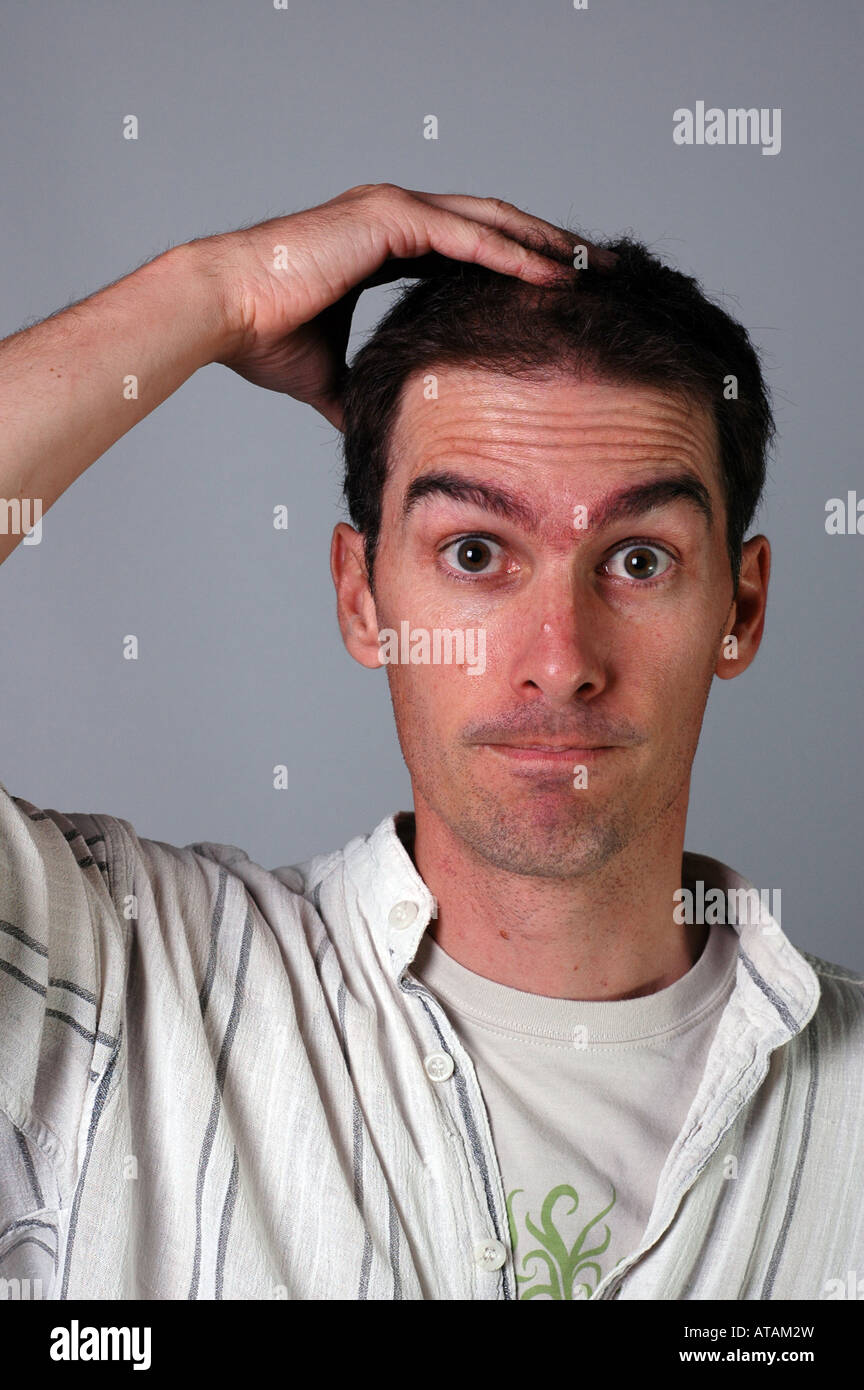 Confused young man slightly scruffy casually dressed Stock Photo