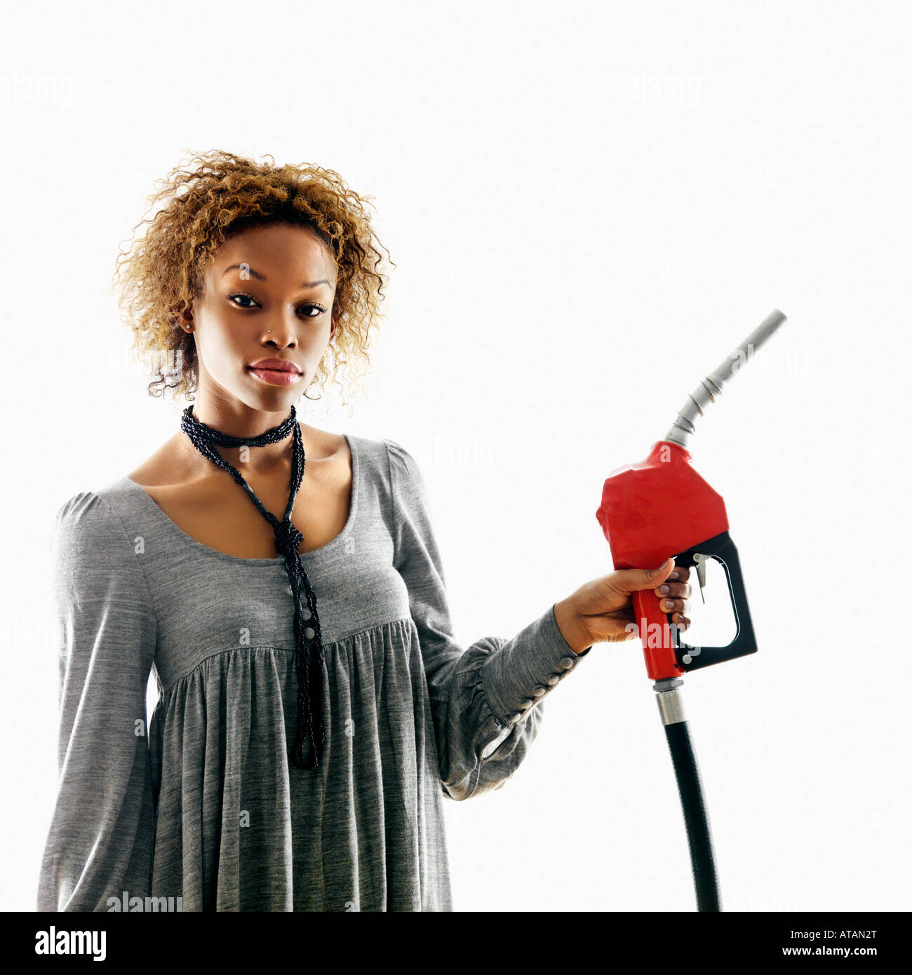 Portrait of pretty young woman holding gas pump nozzle on white background Stock Photo