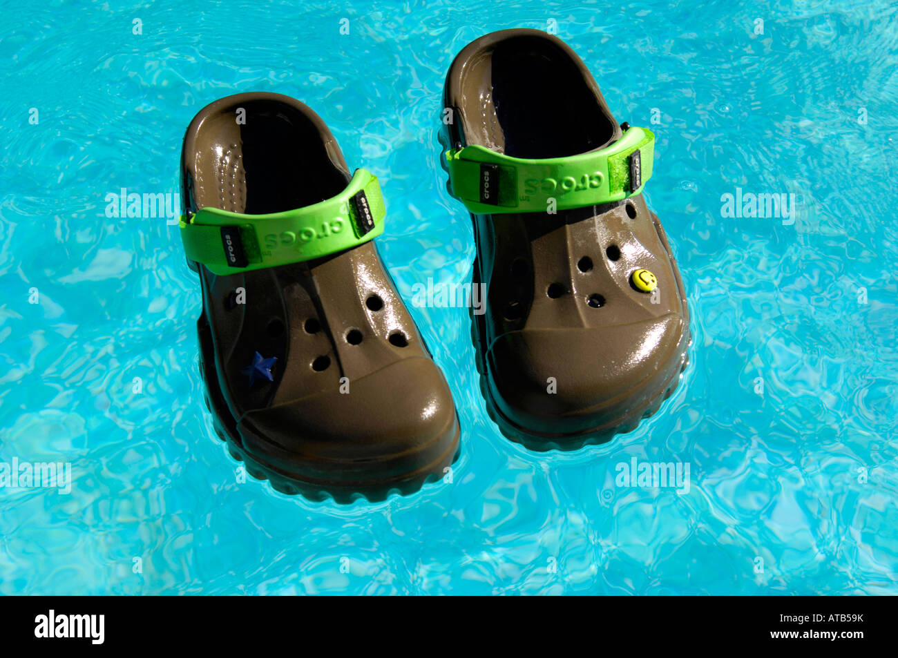 haalbaar gevolg wraak crocs chocolate lime offroad footwear swimming pool floating shoes holiday  vacation blue colour horizontal Stock Photo - Alamy