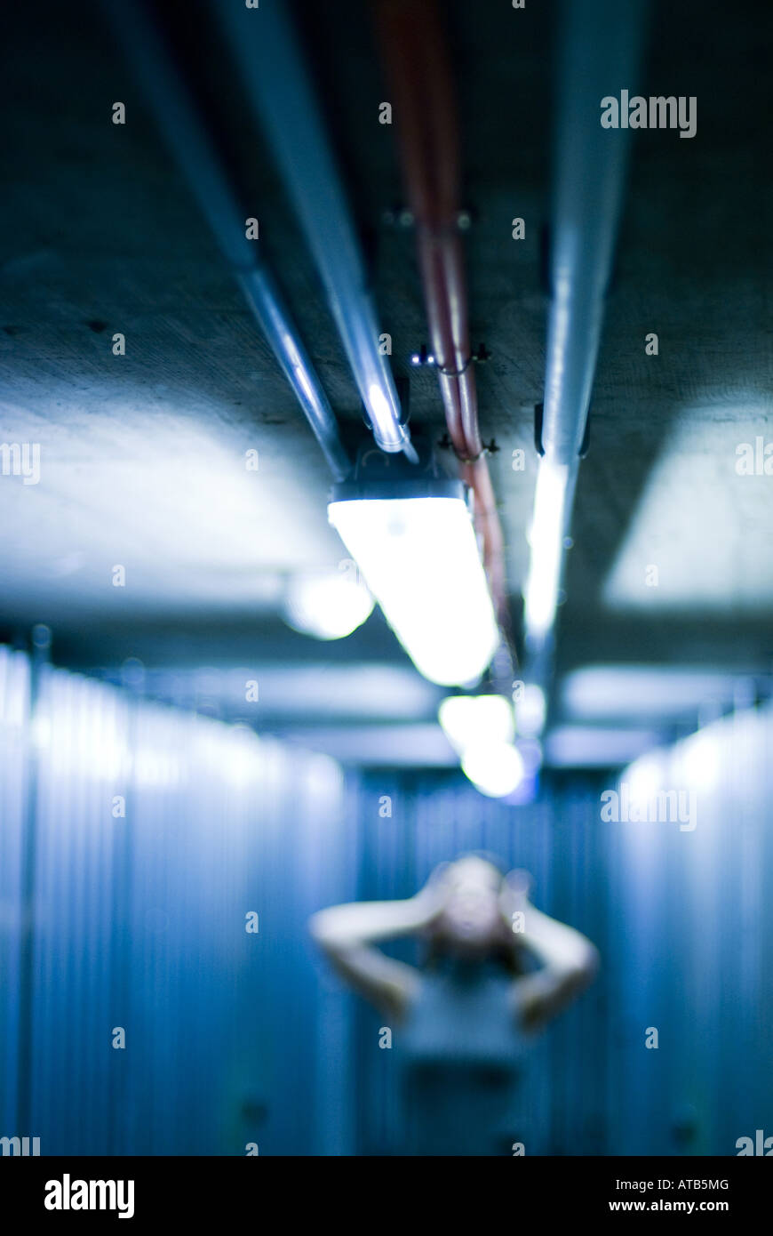 woman posing in an illuminated corridor, in a cellar Stock Photo