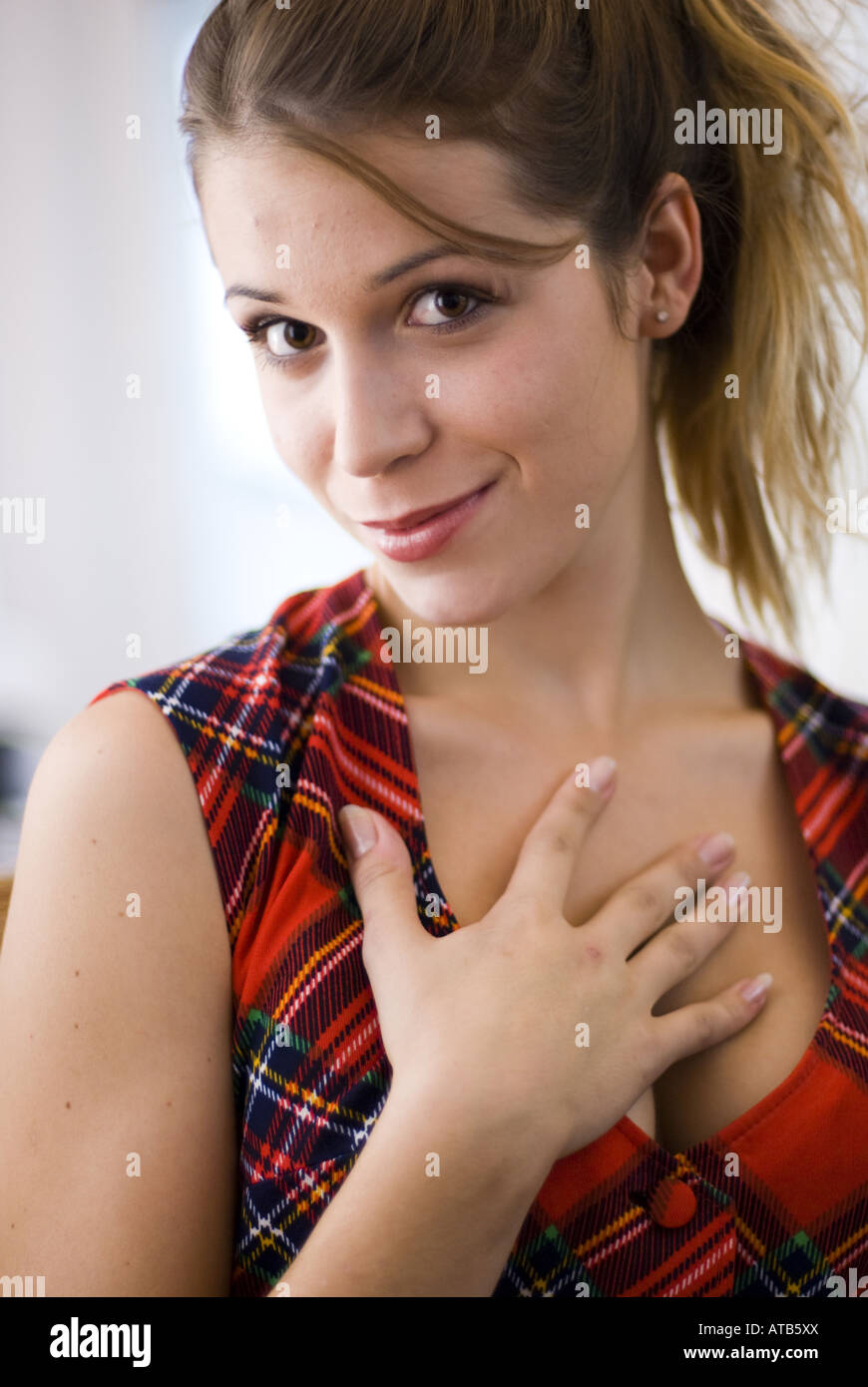 attractive young woman flirting, with her hand on her chest Stock Photo