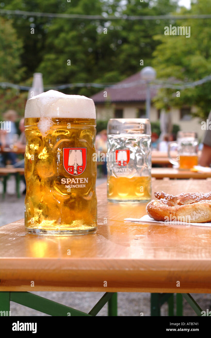 Masskruege und Brezn auf Tisch im Muenchner Biergarten Stock Photo