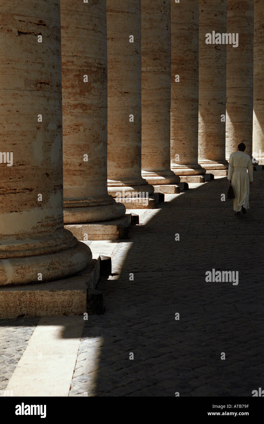 Kirchenmann laeft mit Ledertasche im Schatten auf dem Petersplatz in Rom Italien Stock Photo