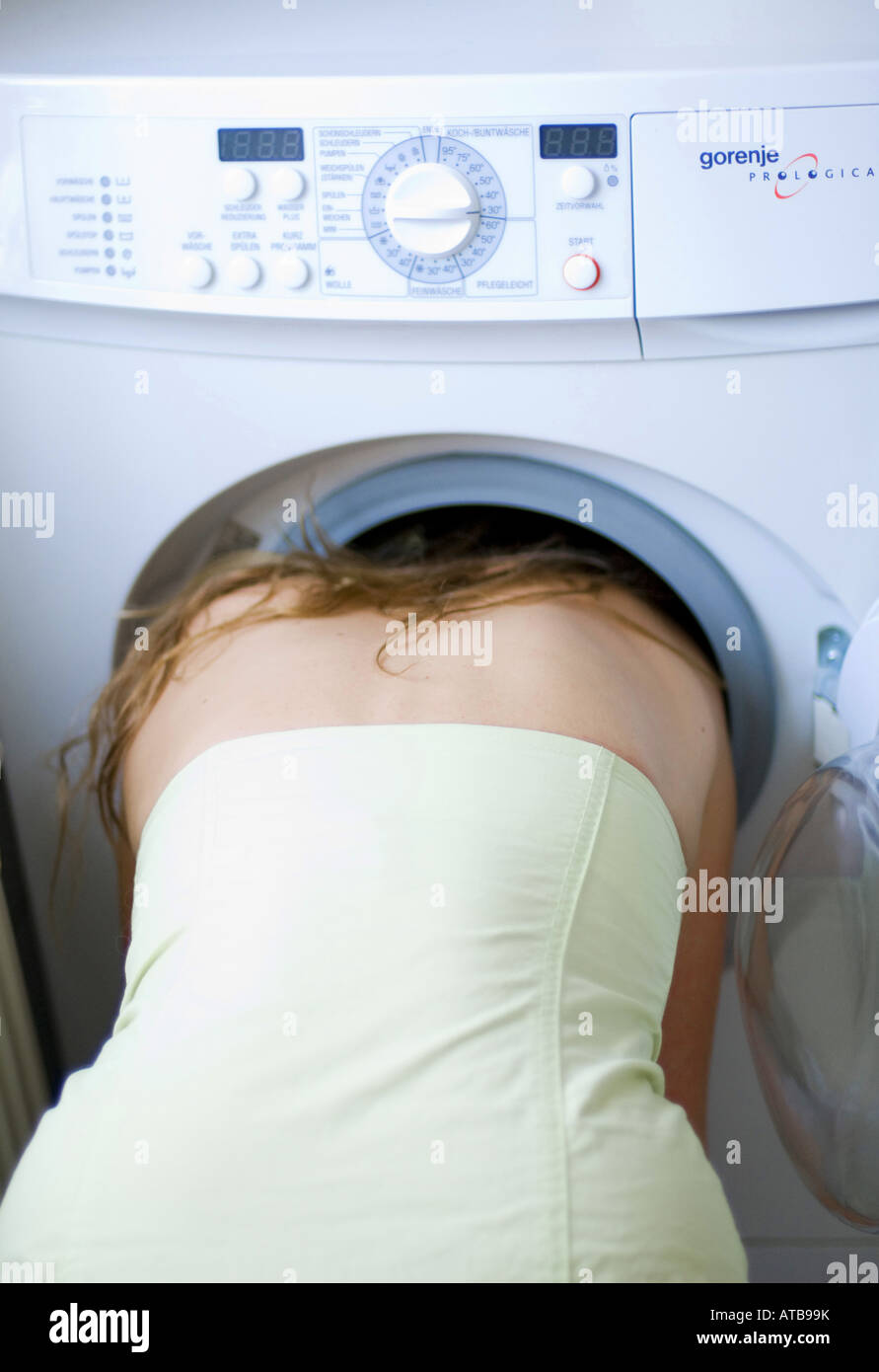 Young woman holding her head in the washing machine Stock Photo - Alamy