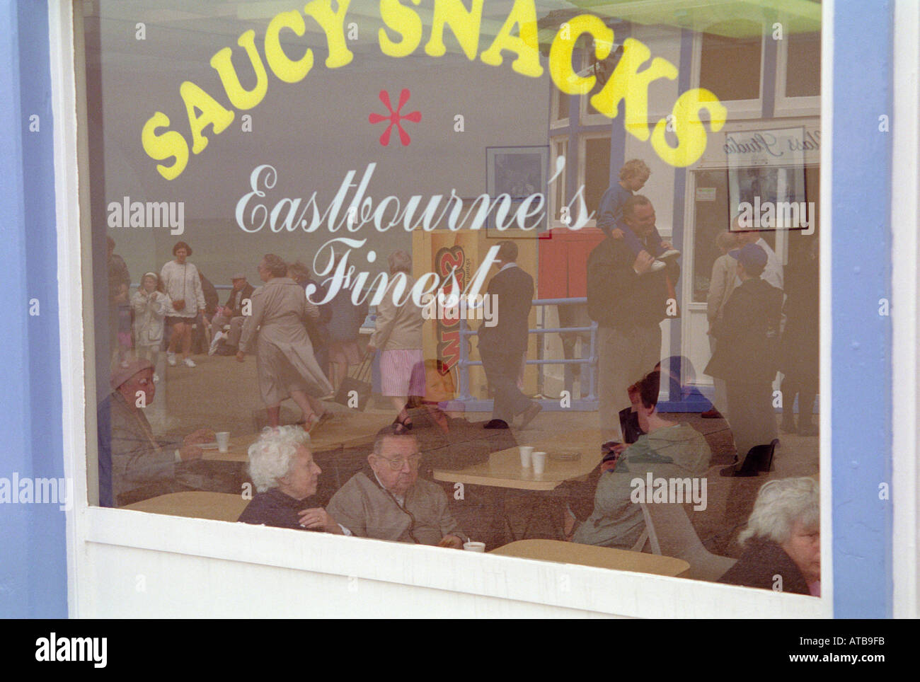 Visitors at the Saucy Snacks cafe on Eastbourne Pier in East Sussex England Stock Photo