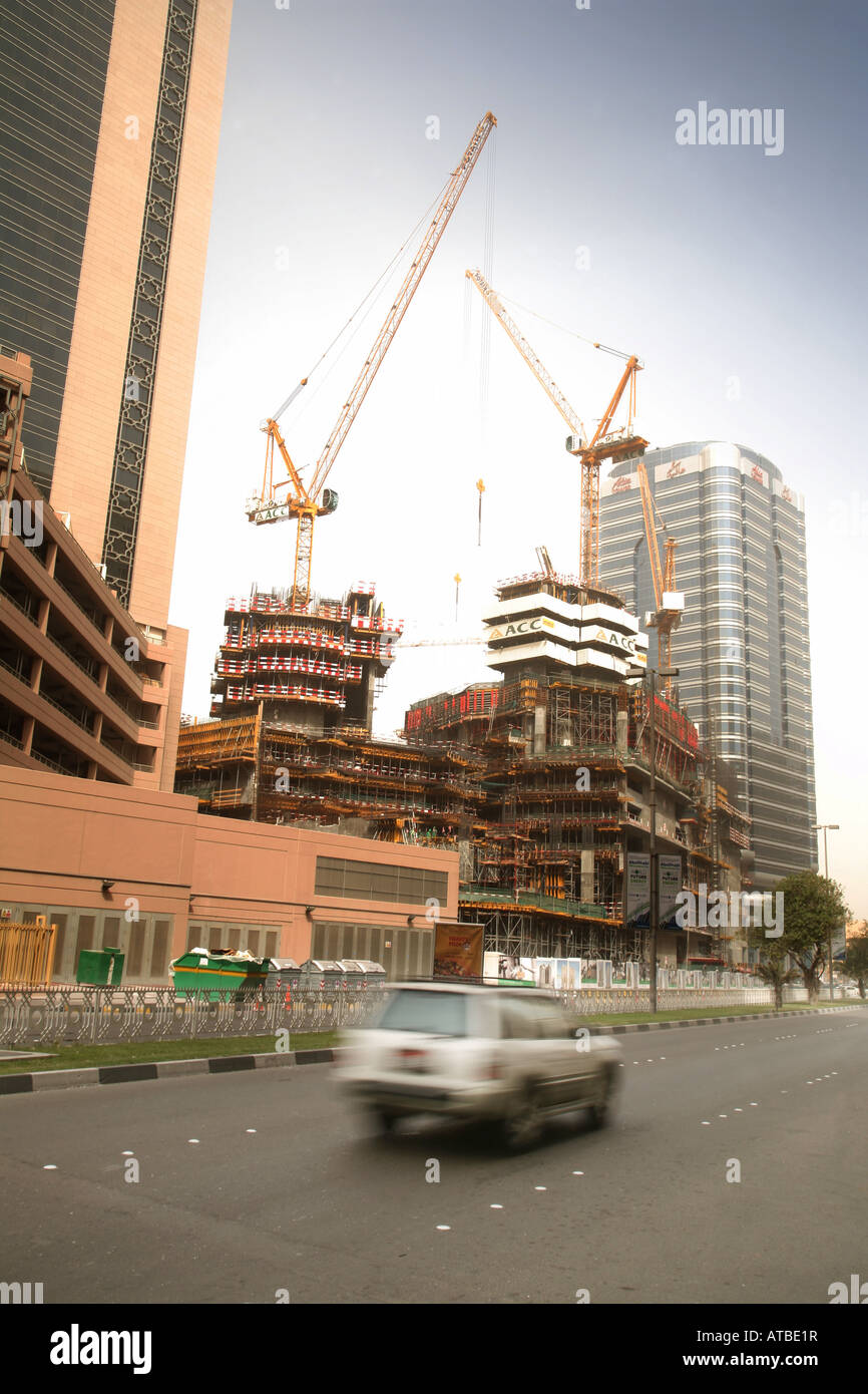 A car speeds past a skyscraper under construction, Abu Dhabi city, UAE Stock Photo