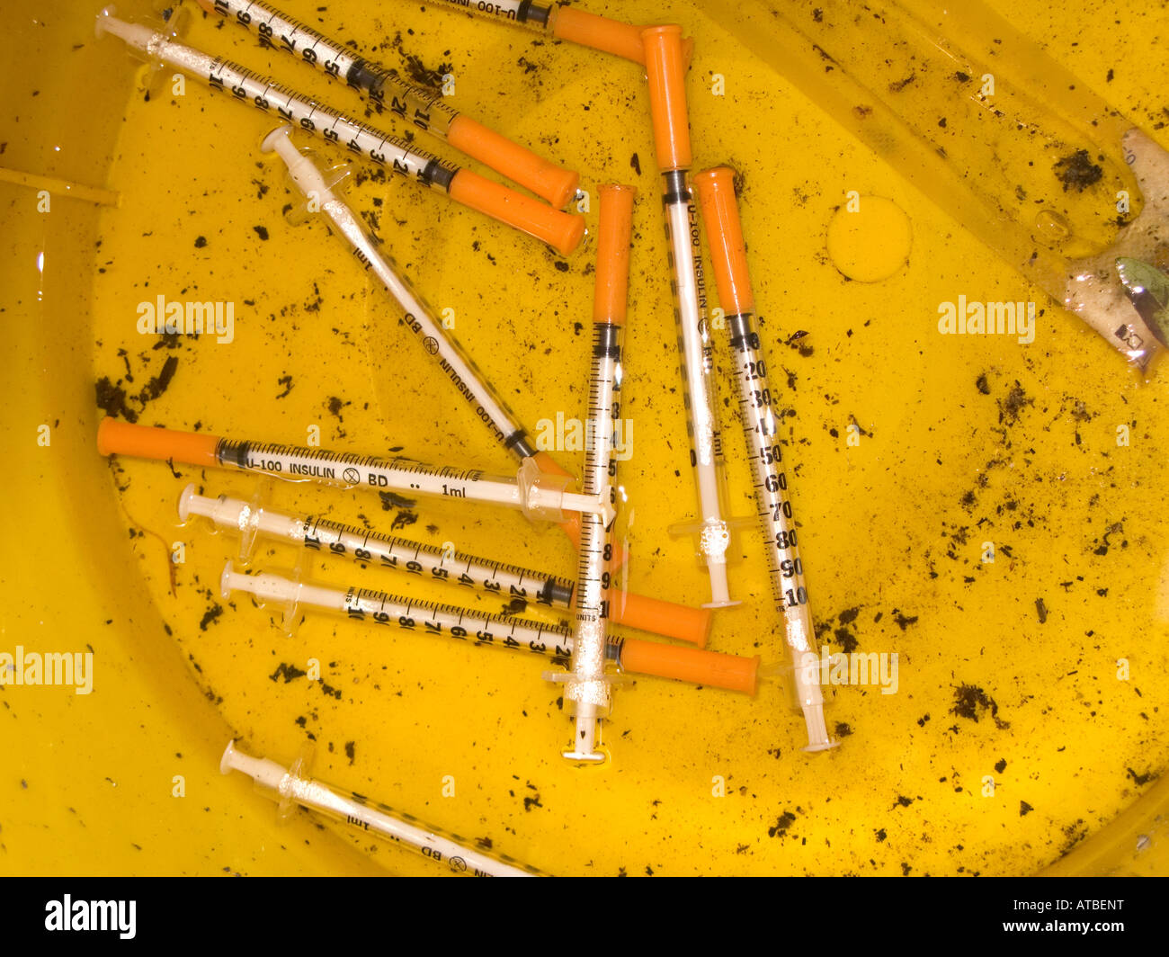 Yellow sharps disposal bucket containing used sharps, Birmingham, UK