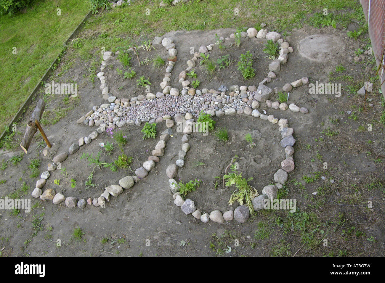 flower bed designed like a butterfly in the garden of a primary school Stock Photo
