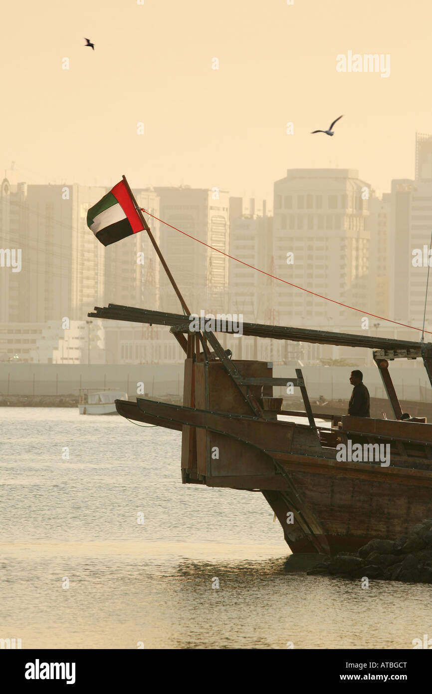 A dhow flying the Emirates flag at sunset, Abu Dhabi city, UAE Stock Photo