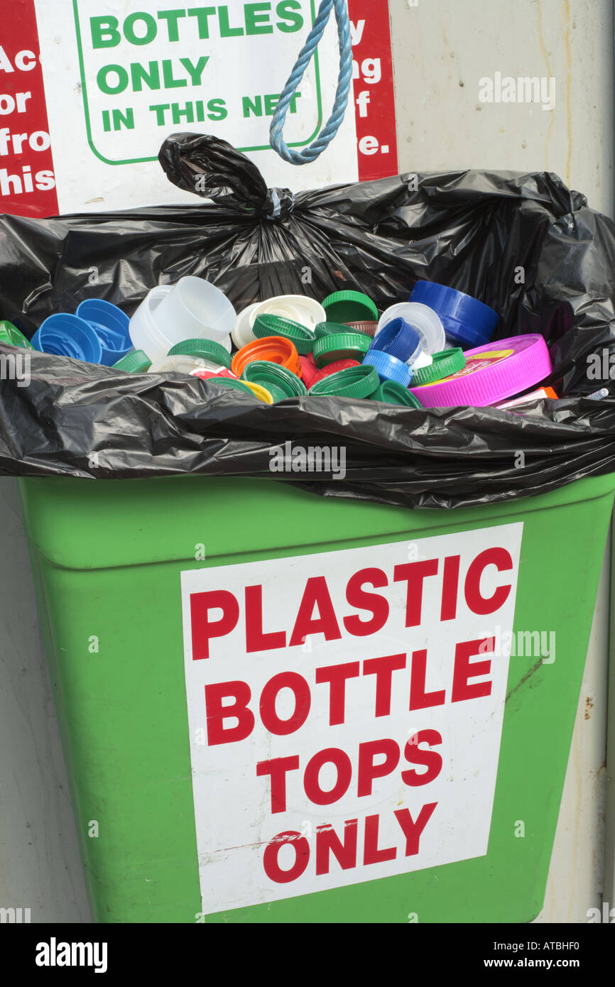 Plastic container full of plastic bottle tops for recycling Stock Photo