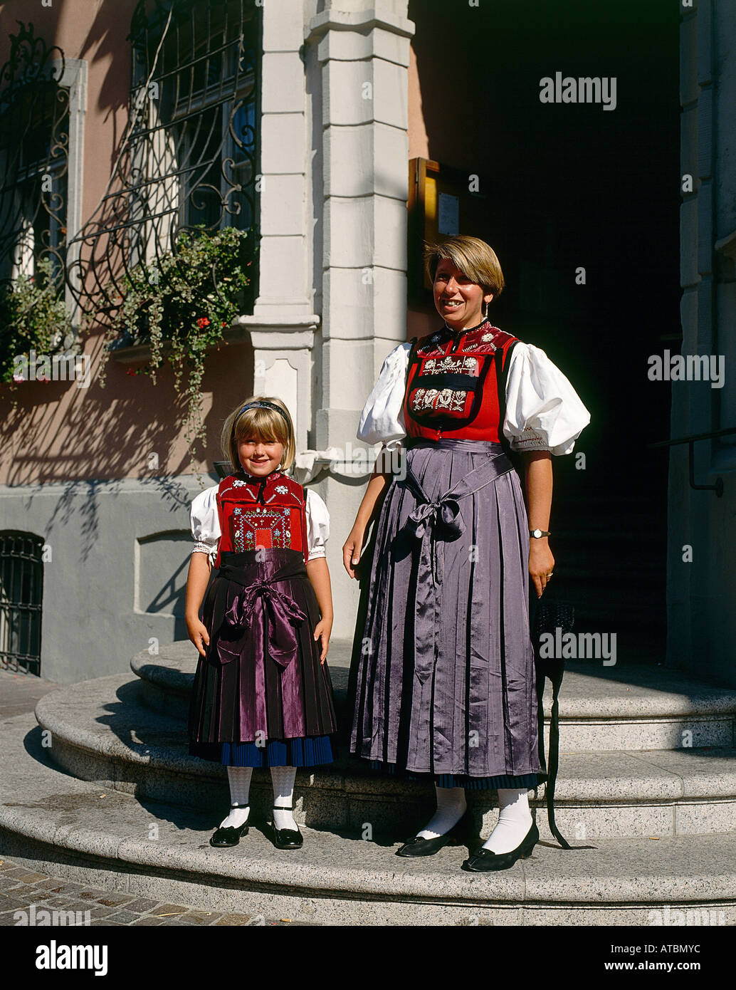 A young local woman and a small girl dressed in colourful national costume in the doorway of a building at Waldshut in southwestern Germany Stock Photo