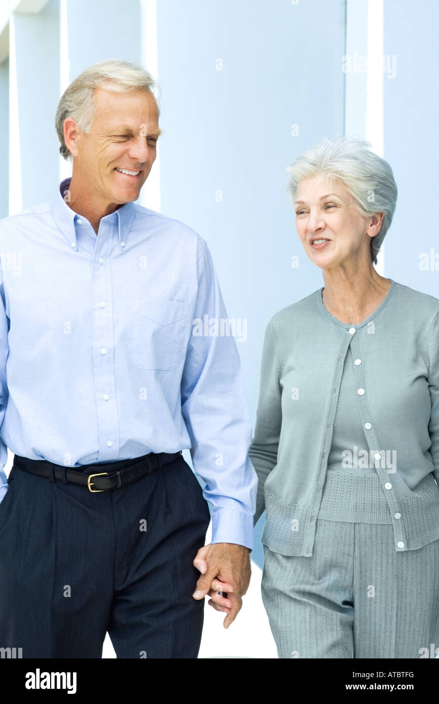Man woman smile holding hands walking hi-res stock photography and ...