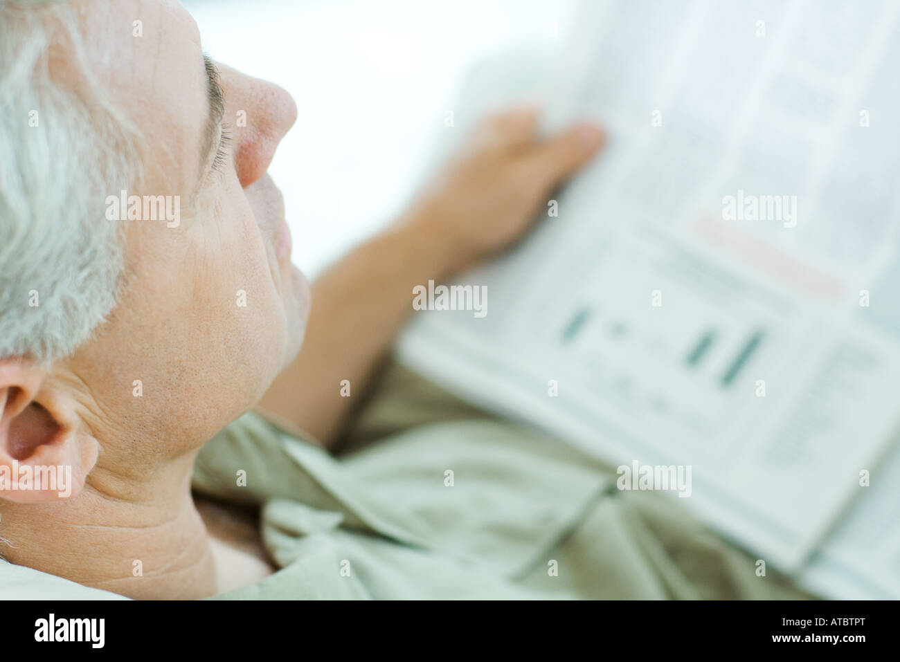 Mature man reading newspaper, high angle view, cropped Stock Photo