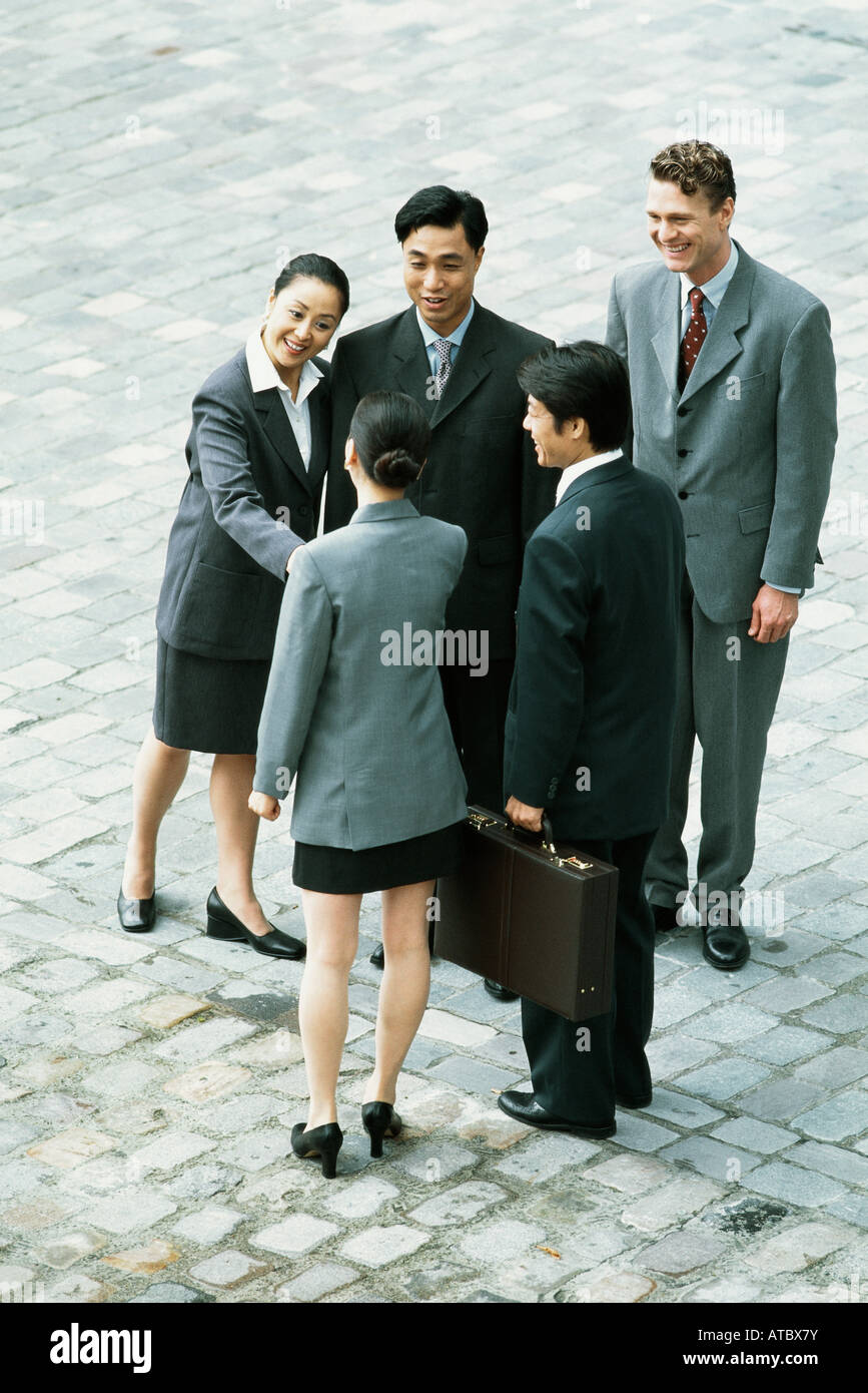 Group of professionals standing together, two women shaking hands, high angle view Stock Photo