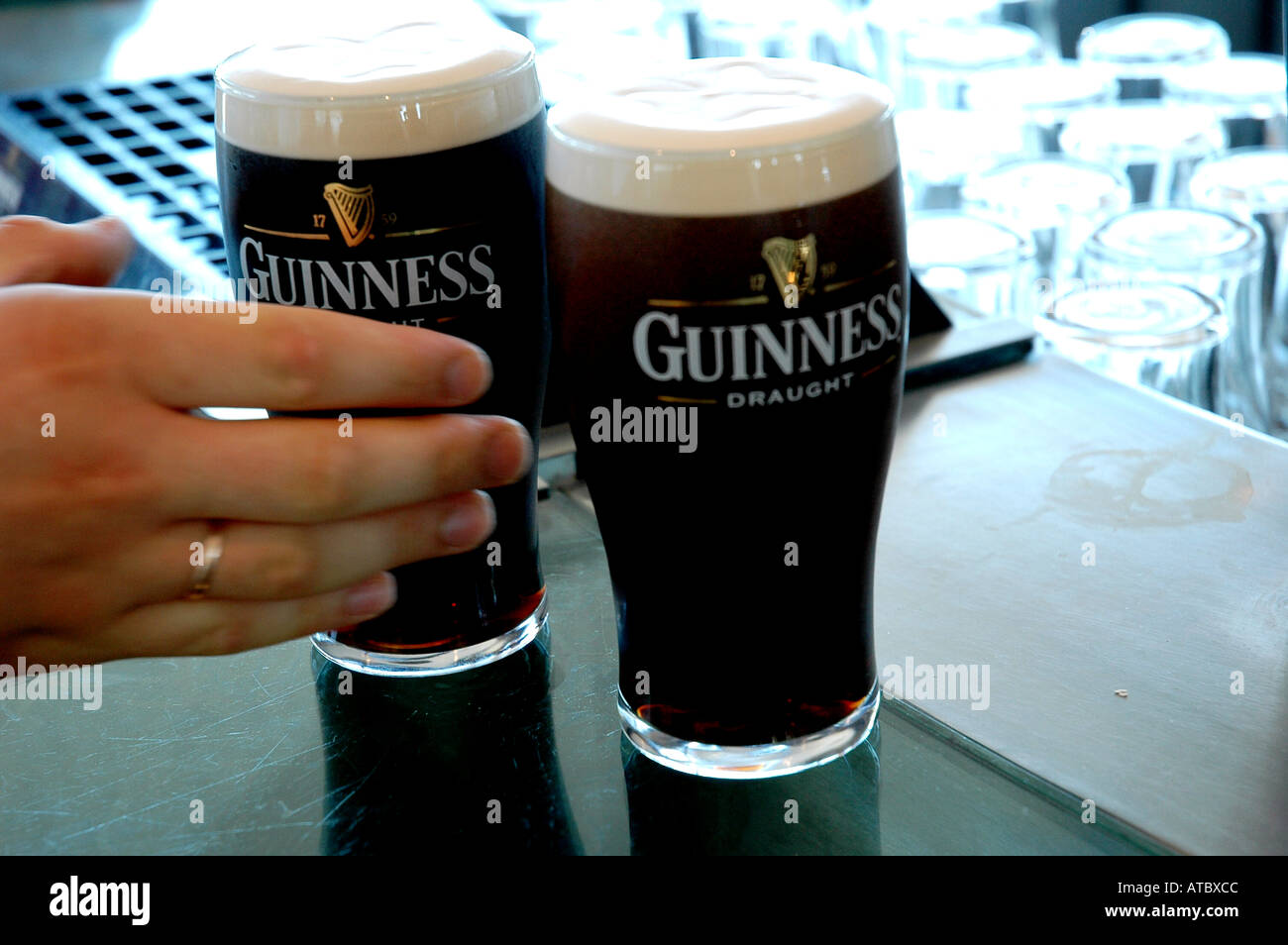A hand Serving pints of Guinness in Dublin Ireland Stock Photo