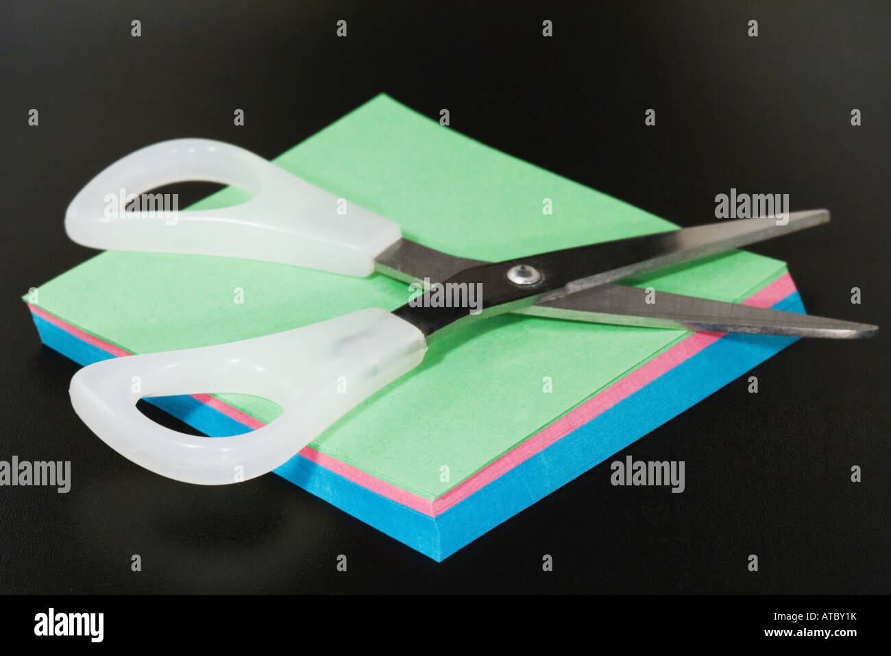 Scissors resting on blank paper, close-up Stock Photo