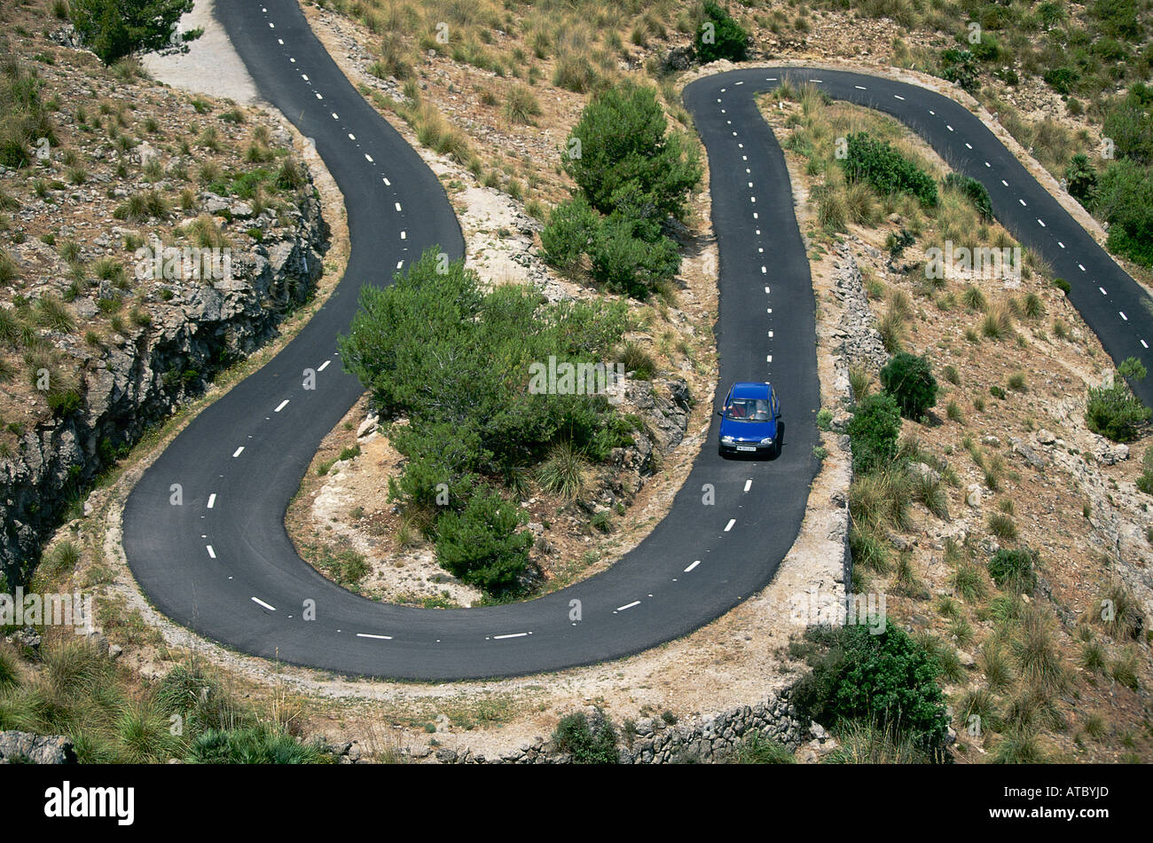 Viewed From Above A Blue Car Heading Towards A Hairpin Bend On One