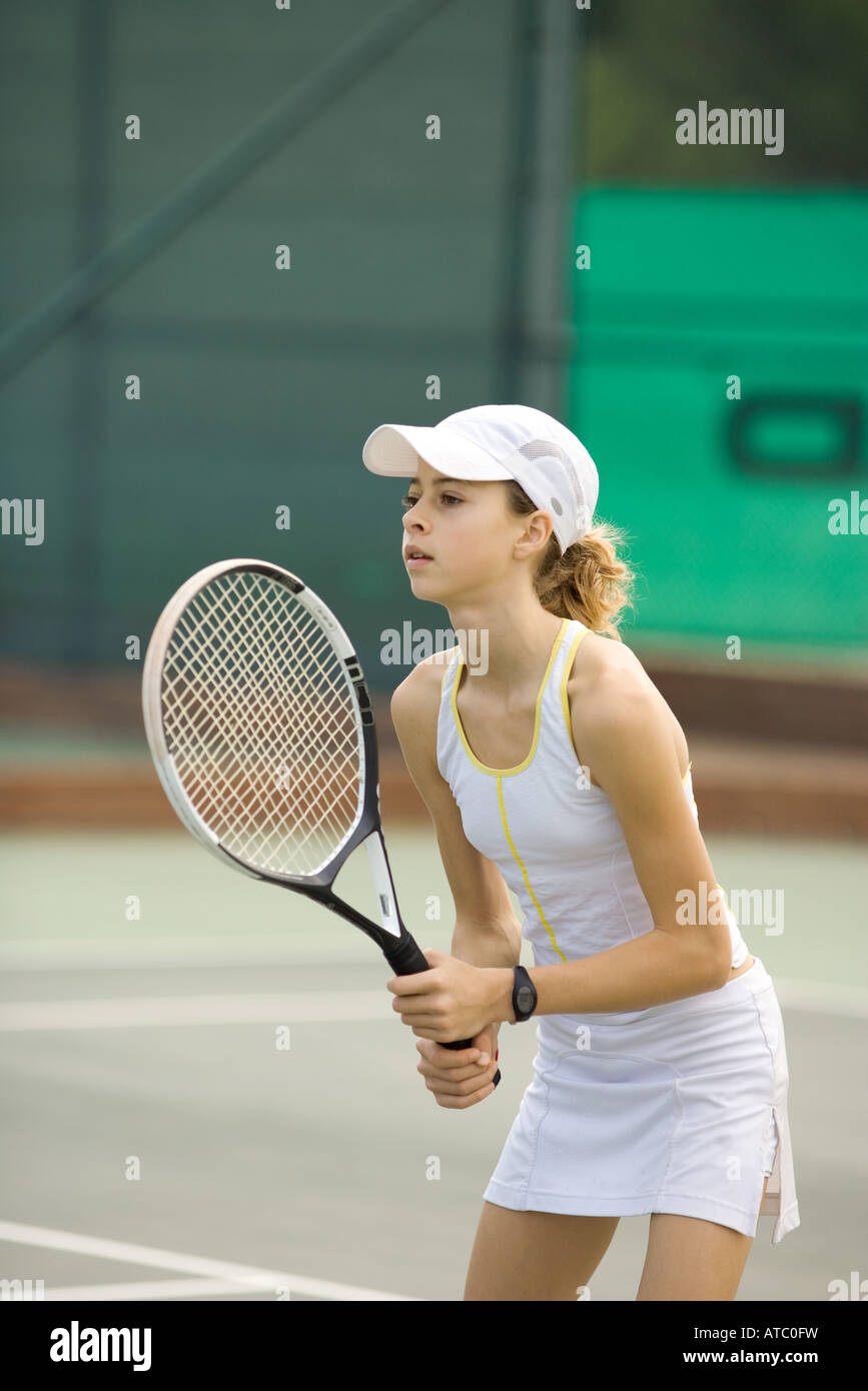 Teenage girl playing tennis, looking away Stock Photo