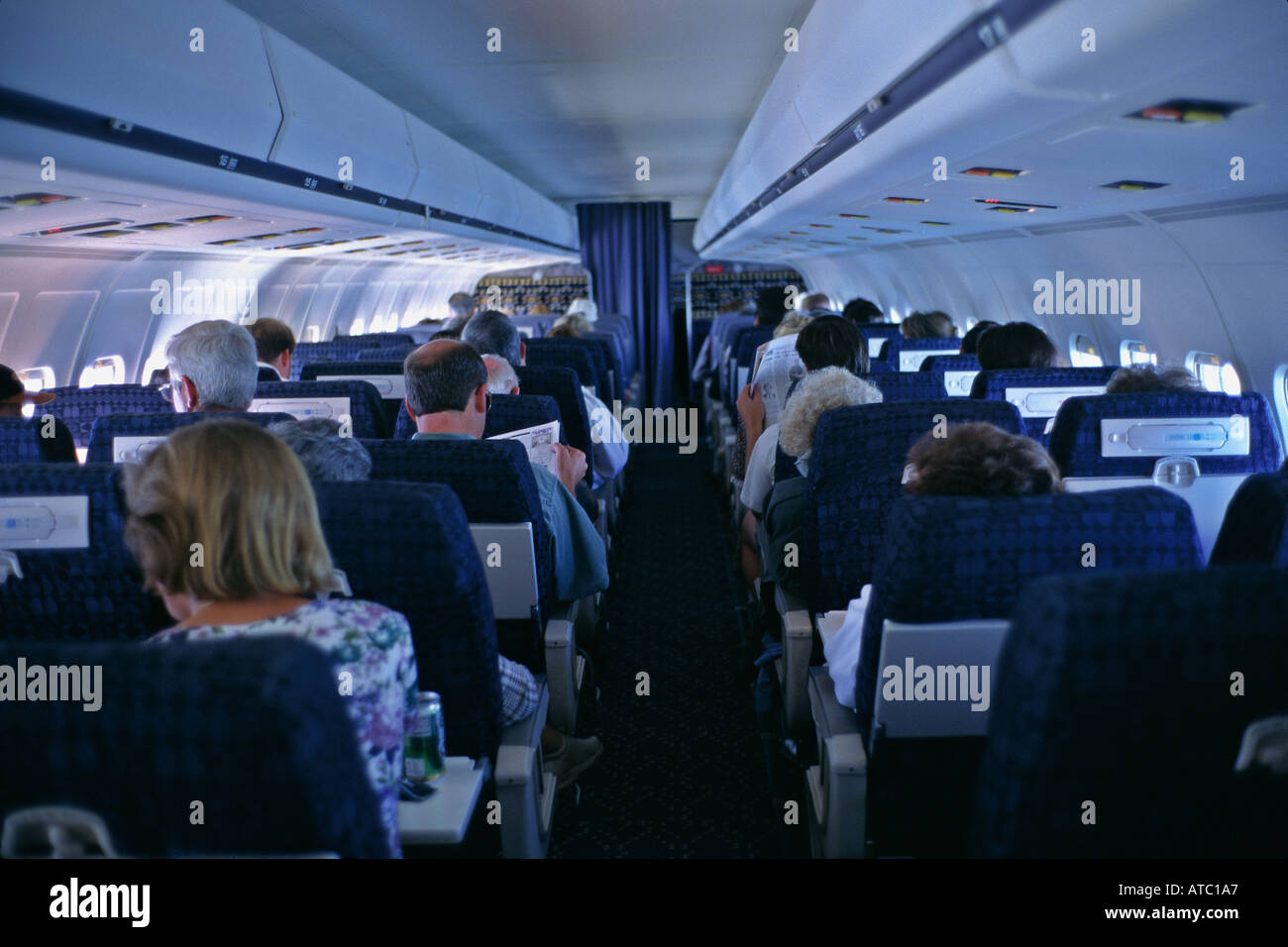 Passengers seated in coach class cabin of Boeing jet aircraft Stock