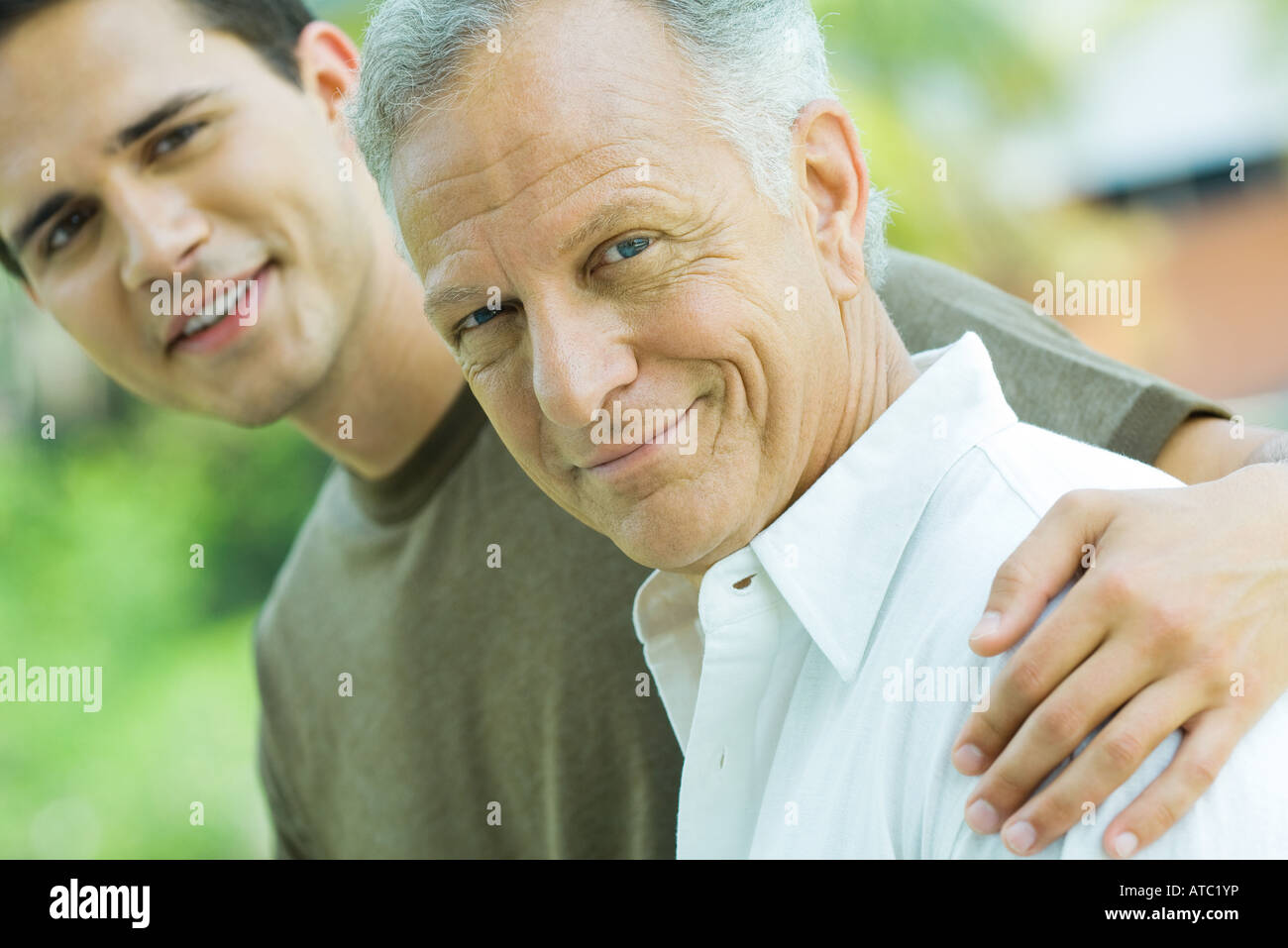 Mature man and adult son smiling at camera together, portrait Stock Photo