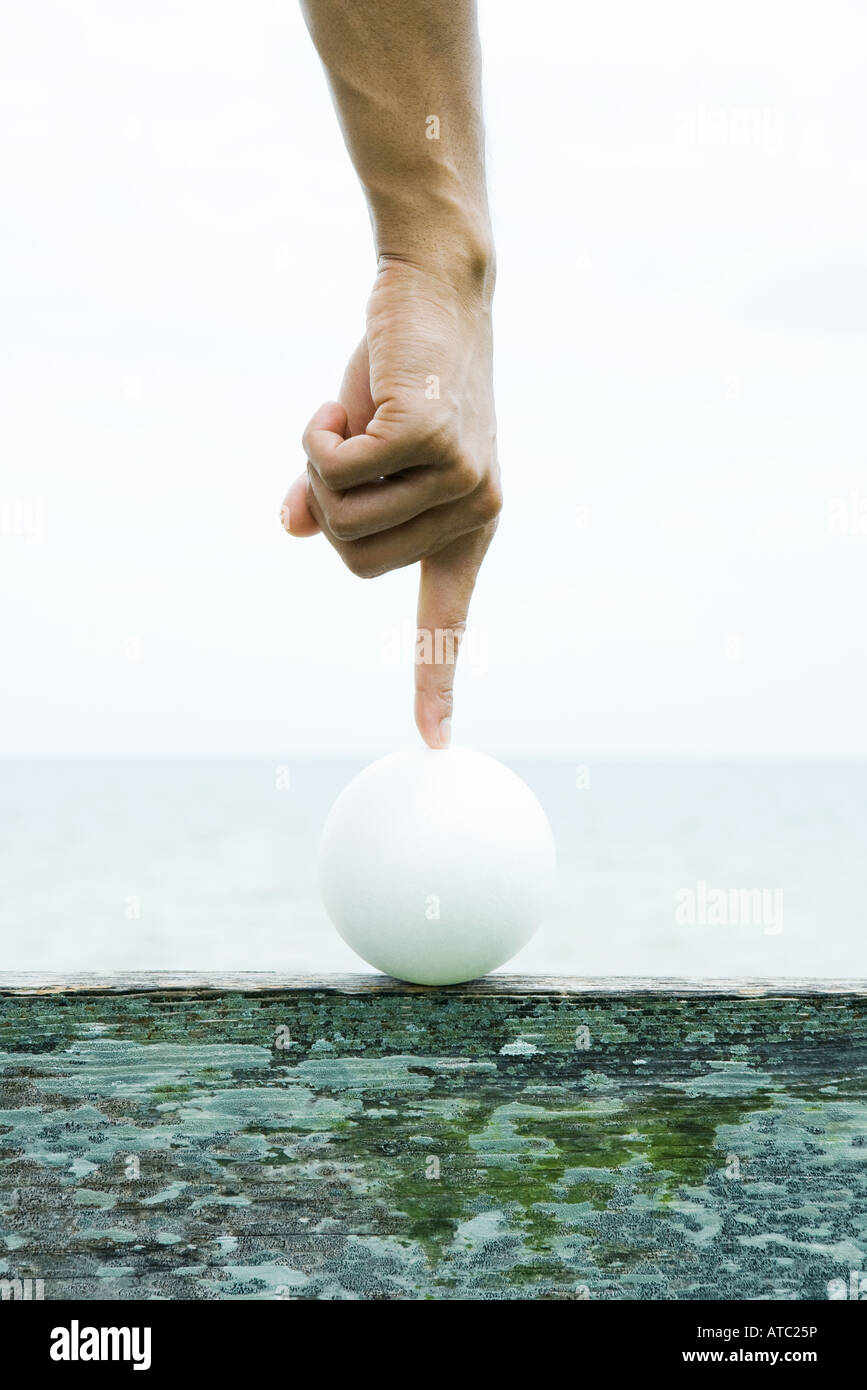 Hand touching ball with forefinger, cropped view Stock Photo Alamy
