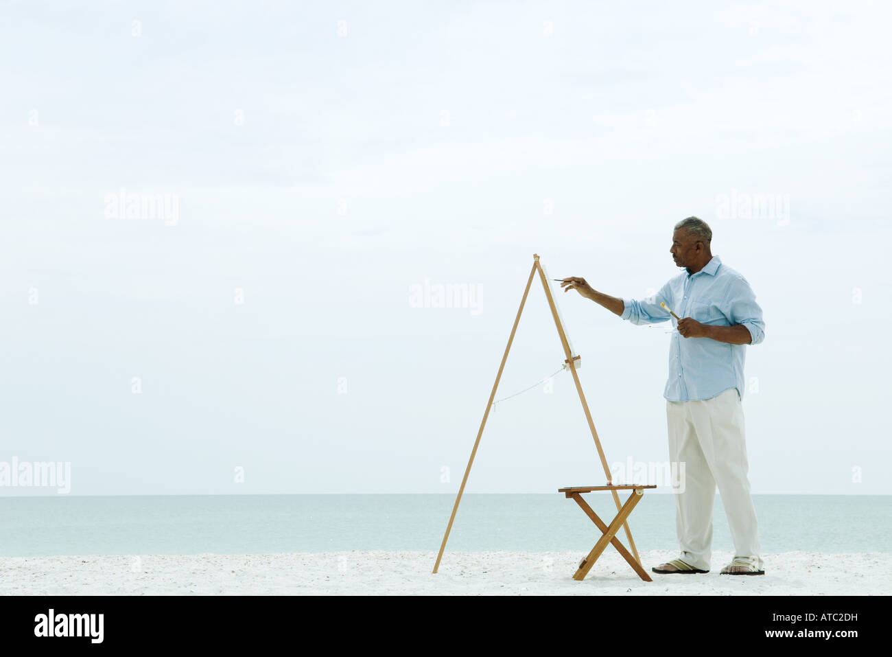 Senior man painting canvas at the beach, side view Stock Photo - Alamy