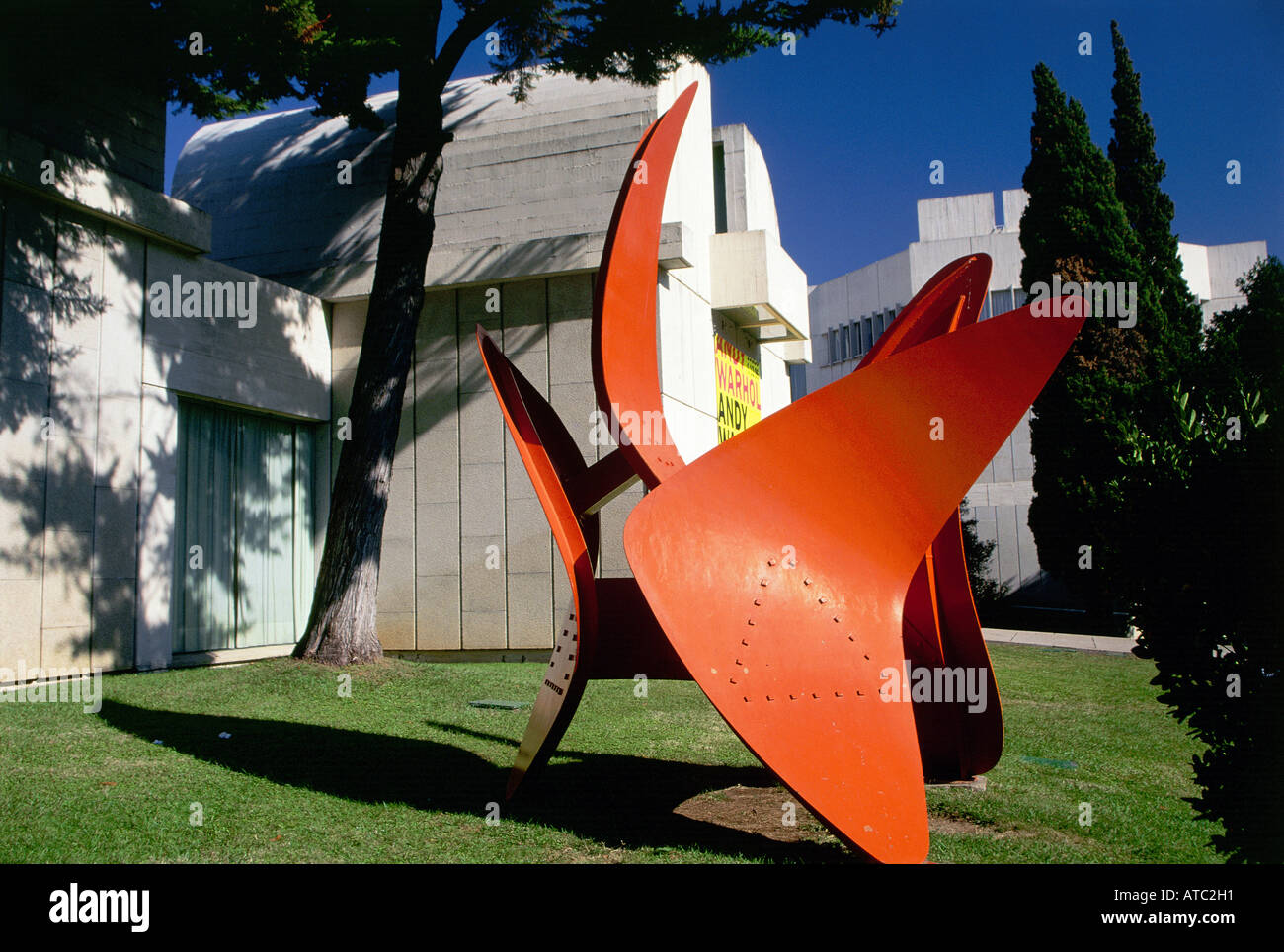 A modern sculpture stands in the shade of a tree outside the Fundacio Joan Miro a white building designed in 1975 by Miro s friend to create a forum for experimentation and study Barcelona Stock Photo