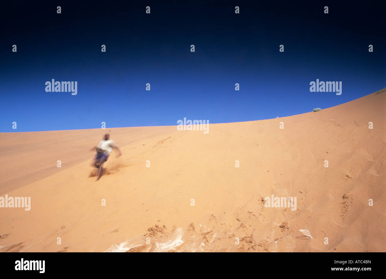 A man running down a sand dune Stock Photo - Alamy