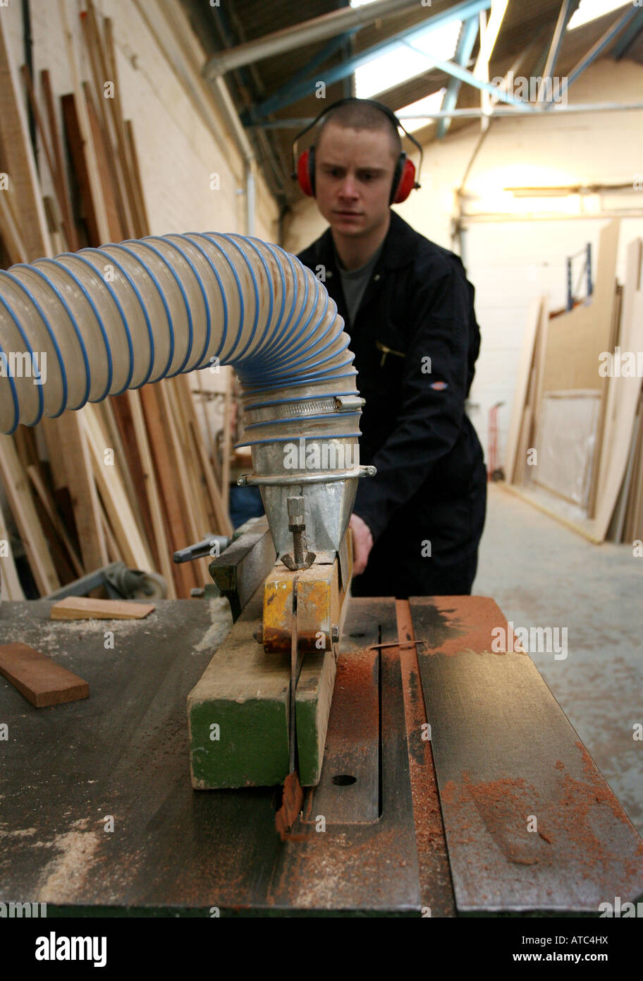 A worker uses an electric saw to cut wood at a Joinery factory in