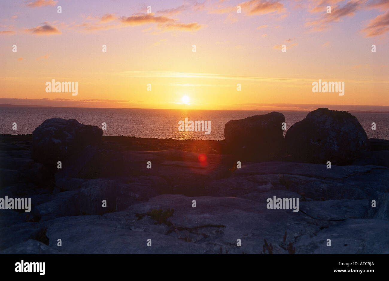 The sun rises over the Burren at Glen Inagh where the Burren meets the sea Stock Photo