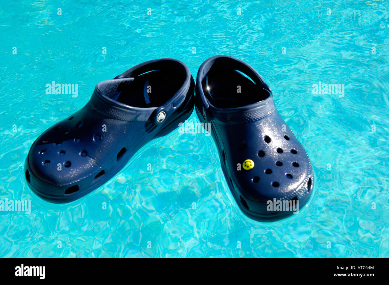 crocs blue beach footwear swimming pool floating shoes holiday vacation  blue colour horizontal Stock Photo - Alamy