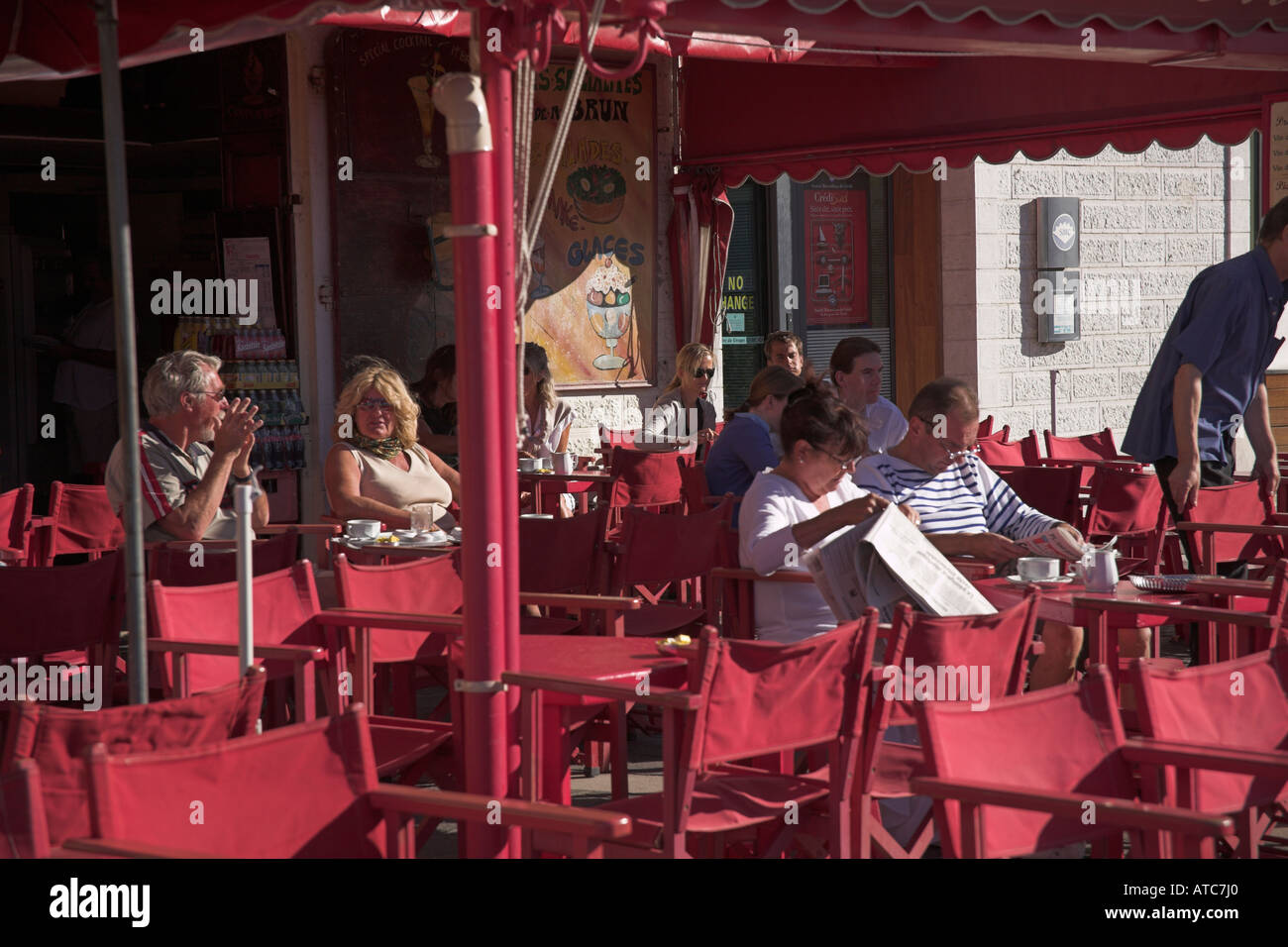 Stock photograph of people taking breakfast at a harbourside cafe in Cassis Provence Stock Photo