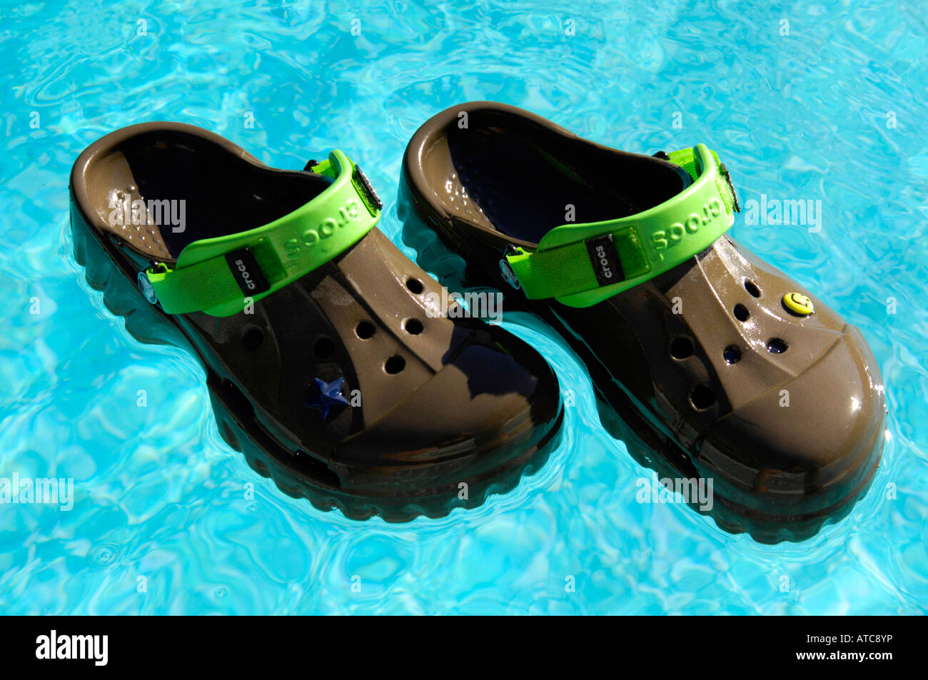 crocs chocolate lime offroad footwear swimming pool floating shoes holiday vacation blue colour horizontal Stock Photo Alamy