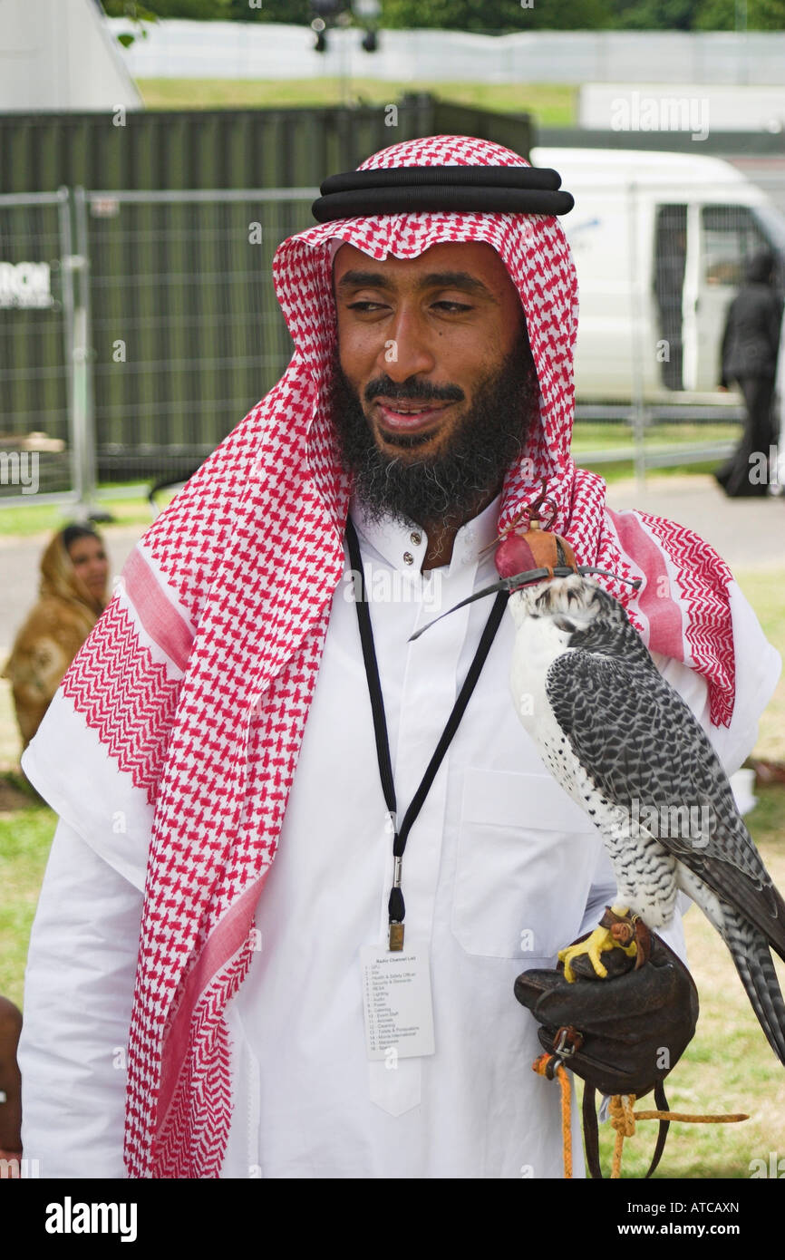 A Saudi man with a hooded falcon at an Arabian fair. Heaton Park, Manchester, Greater Manchester, United Kingdom. Stock Photo
