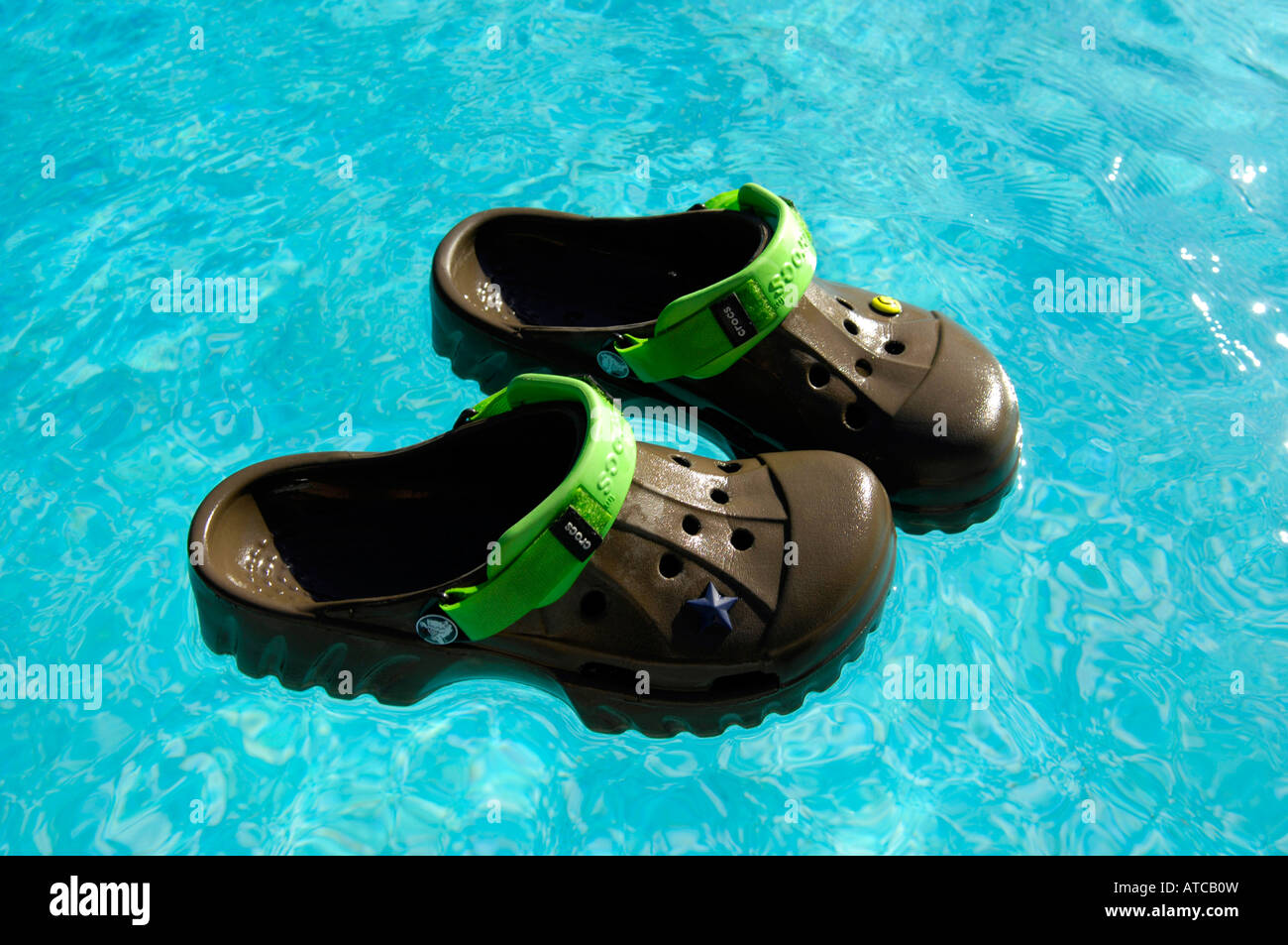 crocs chocolate lime offroad footwear swimming pool floating shoes holiday  vacation blue colour horizontal Stock Photo - Alamy