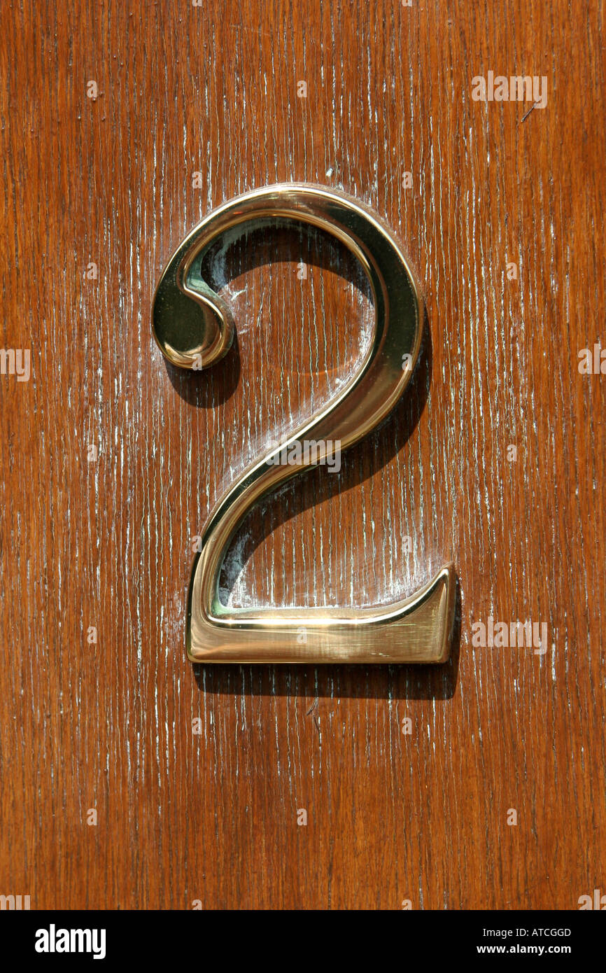 Brass house number two on wooden door Stock Photo